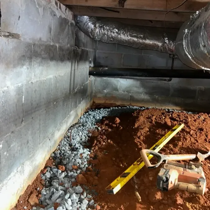 Water pooled beneath a framed floor beside foundation blocks and ductwork