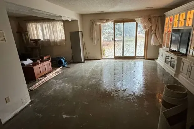 Standing water across the floor of a living room before extraction
